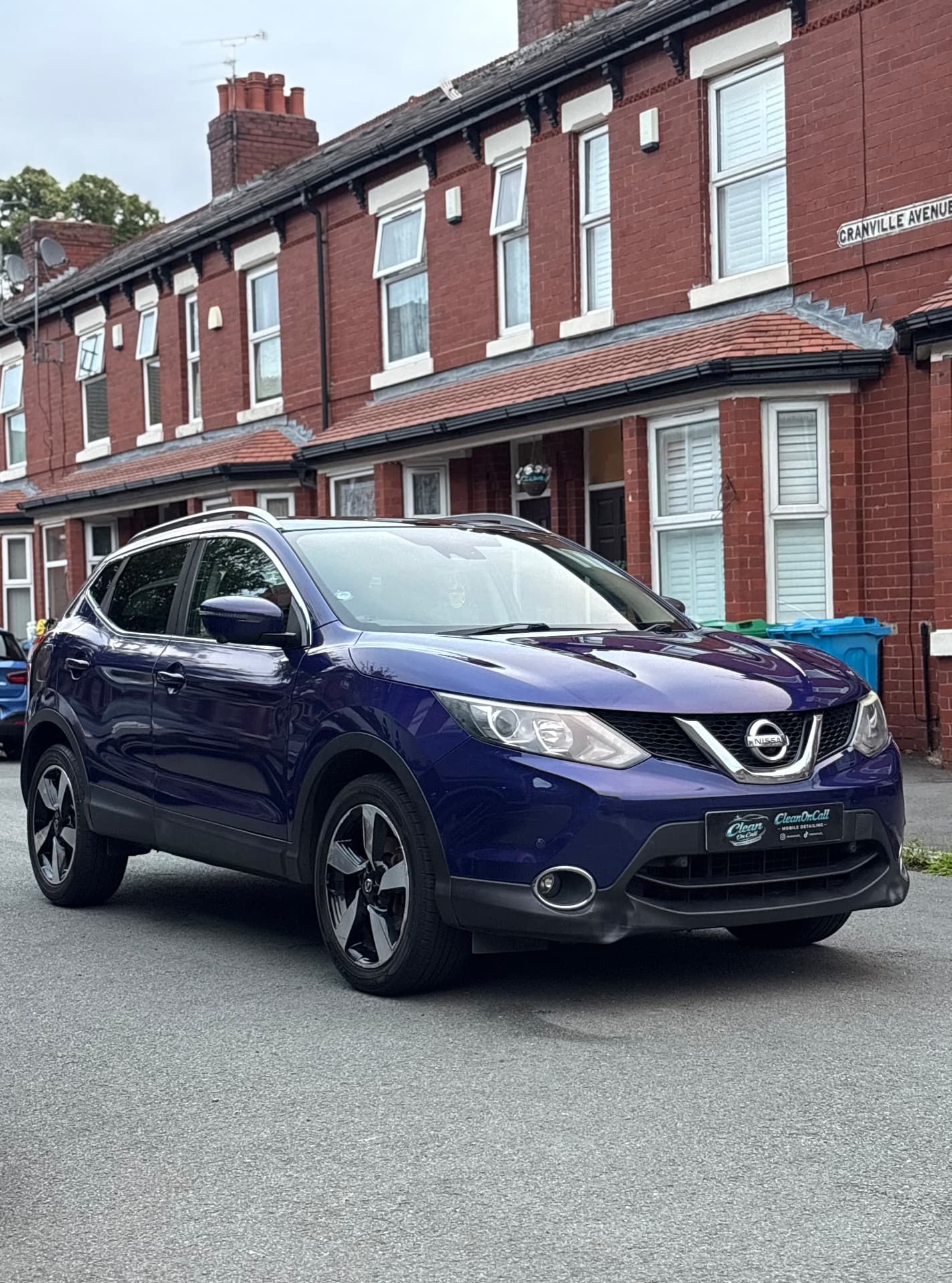 Nissan Qashqai covered in snow foam during a mobile detail on a Manchester street